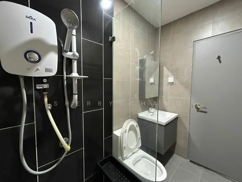 Bathroom features: shower with glass enclosure, rain shower head, handheld shower, white ceramic toilet, single-sink vanity with wall-mounted faucet, mirror above sink, grey tiled walls, black tiled flooring, water heater unit, chrome towel rail; style: modern.