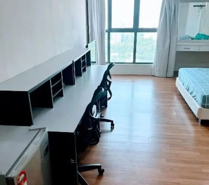 Bedroom features: wooden flooring, large window with city view, double bed with blue bedding, built-in wardrobe, study desk with multiple chairs, mini fridge, curtains, neutral wall color; style: modern; view: city.