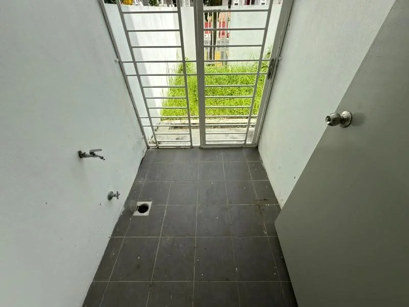 Room features: grey tiled flooring, white painted walls, metal security grille door, window with metal grille, plumbing fixtures visible, drainage outlet on floor; view: garden.