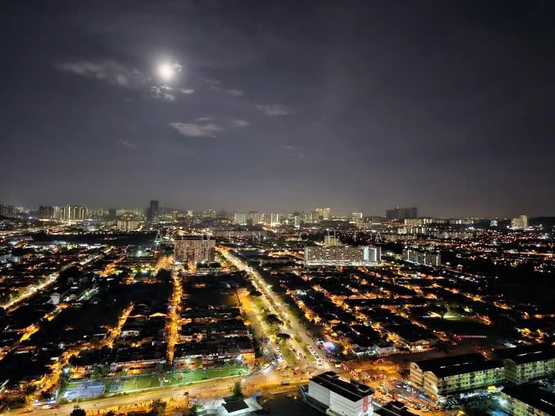 Exterior type: high-rise condominium; features: city skyline view, nighttime lighting, moon visible in the sky, urban landscape, surrounding residential areas, main road illuminated, high-rise buildings in the background; style: modern.