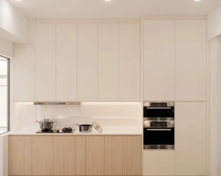 Kitchen features: white cabinetry with flat-panel doors, light wood lower cabinetry, white countertop, built-in oven, built-in microwave, 4-burner gas hob, stainless-steel pot, stainless-steel lid, under-cabinet lighting, single-bowl stainless-steel sink, window with natural light; style: modern.