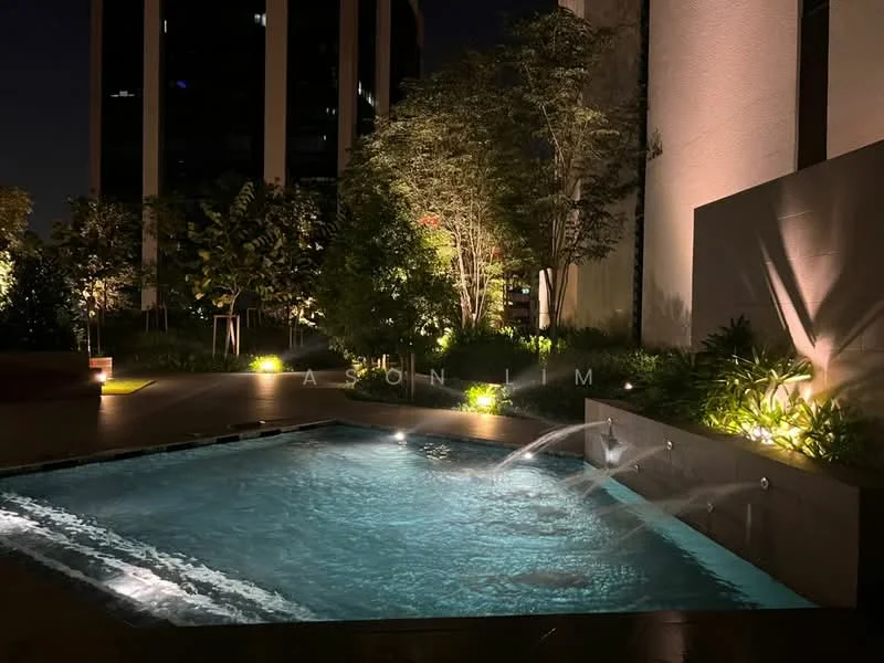 Exterior type: swimming pool deck; features: infinity edge pool, water feature with fountain, landscaped garden with greenery, ambient lighting, surrounding trees, tile flooring around pool, nighttime illumination; style: modern.