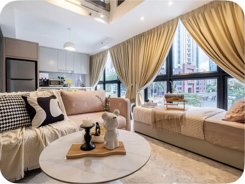 Living features: beige fabric sofa, black and white patterned throw pillow, round coffee table with wooden base, decorative candle, stuffed bear decoration, large windows with sheer curtains, light-colored area rug, wooden cabinetry, kitchenette with built-in appliances, neutral wall color, recessed ceiling lights; style: modern; view: city.