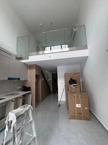 Room features: white painted walls, grey tiled flooring, open staircase, glass railing, kitchen cabinetry with blue accents, kitchen countertop, air conditioning unit, large windows for natural light, unpacked cardboard boxes, ladder, high ceiling; style: modern.