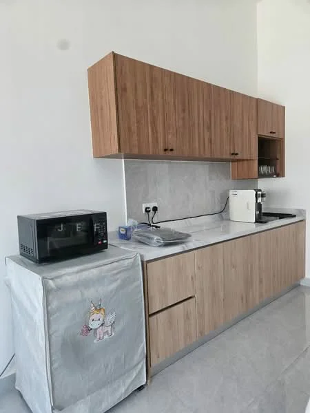 Kitchen features: wood cabinetry with brown finish, white marble countertop, stainless-steel sink, chrome faucet, built-in microwave, refrigerator with decorative cover, wall-mounted electrical outlets, grey tile backsplash, grey ceramic tile flooring; style: modern.