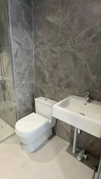 Bathroom features: grey marble tile walls, white ceramic toilet, single-sink vanity with wall-mounted faucet, chrome basin mixer, glass shower enclosure, rain shower head, white ceramic sink, tile flooring, built-in storage under sink; style: modern.