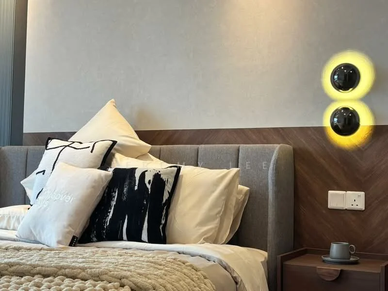 Bedroom features: king-size bed, upholstered headboard, decorative throw pillows, white bedding, textured blanket, wooden bedside table, wall-mounted lighting fixtures, grey accent wall, wood paneling, coffee cup on bedside table; style: modern.