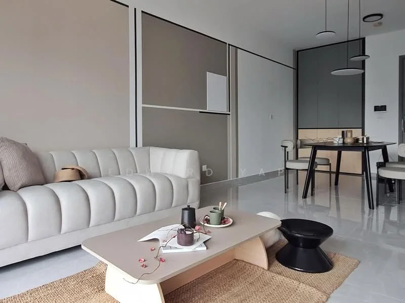 Living features: light grey tufted fabric sofa, round black side table, light wood coffee table, white walls, cream accent wall, polished tile flooring, recessed downlights, pendant light fixture, dining table with black chairs, decorative items on coffee table; style: modern.