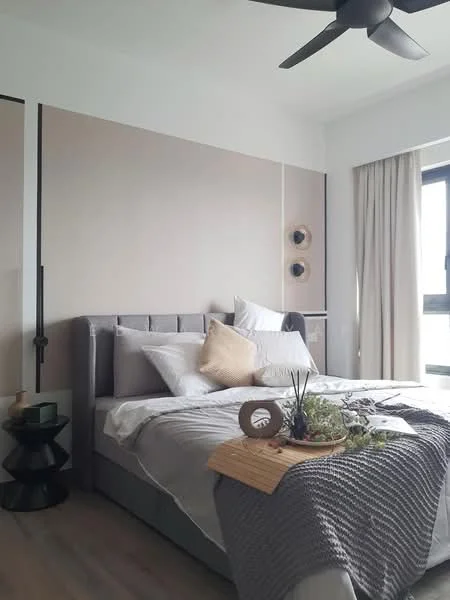 Bedroom features: king-size bed with upholstered headboard, white bedding with decorative pillows, grey throw blanket, nightstand with decorative items, black ceiling fan, floor-to-ceiling window with sheer curtains, light wood flooring, wall-mounted decor, accent wall with beige panels; style: modern.