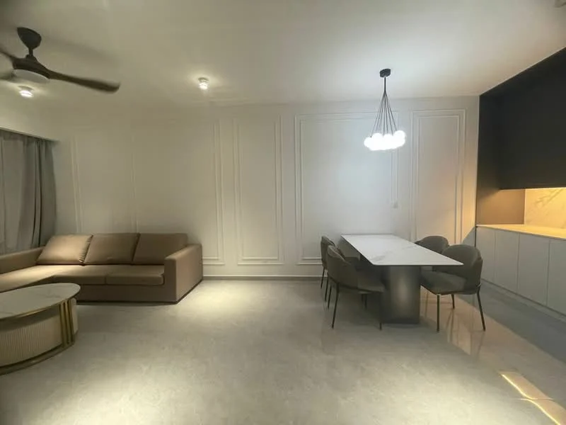 Living features: 3-seater fabric sofa in beige, round coffee table with gold base, dining table with white marble top, 4 upholstered dining chairs, recessed downlights, ceiling fan, grey curtains, white painted walls with paneling, polished marble flooring, kitchen cabinetry with light wood finish; style: modern.