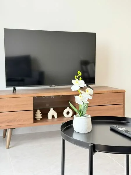 Living features: wall-mounted TV, wooden TV console, black round coffee table, decorative vase with flowers, ceramic decorative objects, light-colored walls, tile flooring, natural light from window; style: modern.