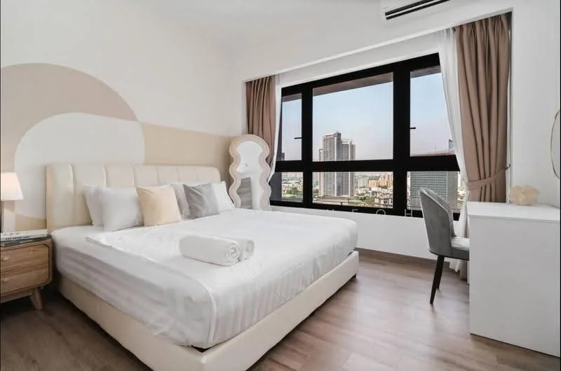 Bedroom features: king-size bed with upholstered headboard, white bed linens, 2 decorative pillows, wooden bedside table, table lamp, large window with city view, curtains, light wood flooring, white walls with accent design, study desk with chair; style: modern; view: city.