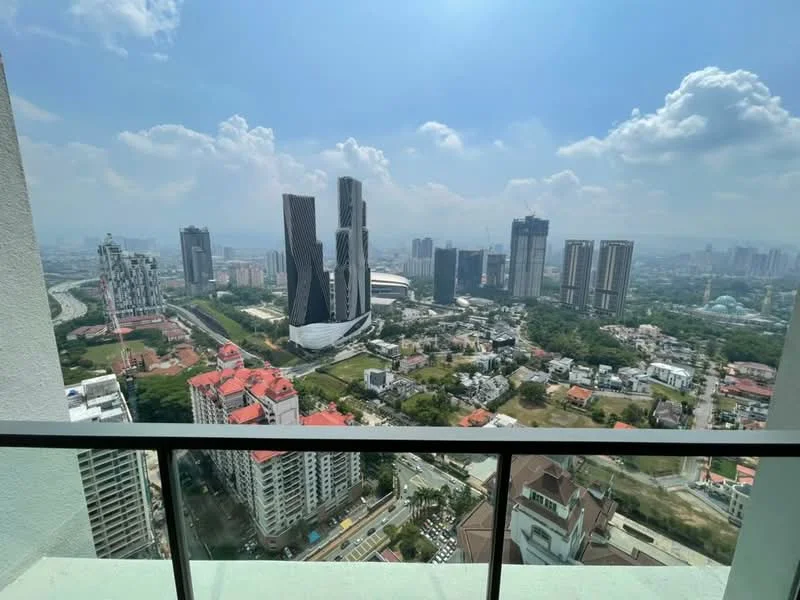 Exterior type: high-rise condominium; features: city skyline view, glass facade buildings, surrounded by greenery, urban landscape, high-rise structures, rooftop gardens, mixed-use development, open-air balcony, clear blue sky, clouds, roadway visible below; style: modern.