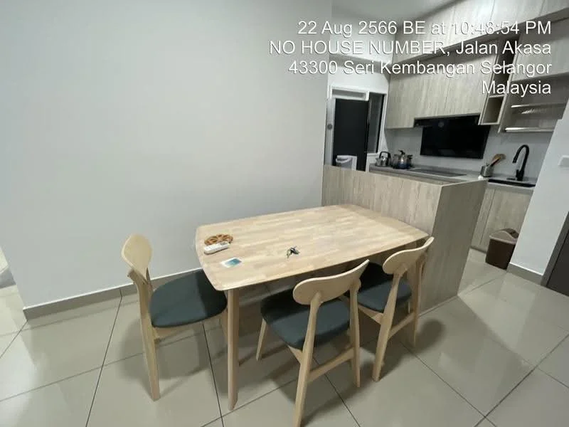 Dining features: wooden dining table, 4 dining chairs, grey upholstered chairs, kitchen island, stainless-steel sink, black faucet, wood cabinetry, white walls, tile flooring, recessed lighting; style: modern.