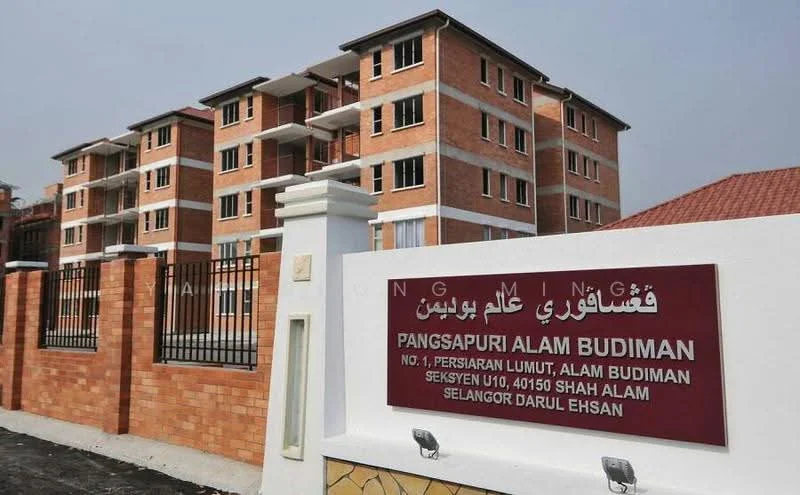 Exterior type: low-rise apartment block; features: red brick facade, white painted accents, balconies with sliding glass doors, gated entrance, manicured landscaping, fence with decorative pillars, multiple storeys, visible windows, roof with tiles; style: modern.