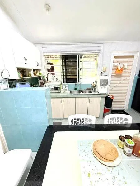 Kitchen features: light blue tiled backsplash, white cabinetry with black handles, black countertop, stainless-steel sink, chrome faucet, built-in kitchen appliances, window with view to outside, open shelving, dining table with white chairs, decorative items on countertop; style: modern.