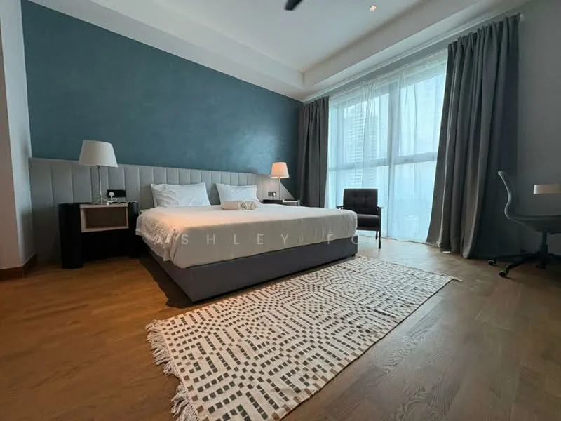 Bedroom features: king-size bed with white bedding, upholstered headboard, two bedside lamps, wooden flooring, grey accent wall, floor-to-ceiling windows with sheer curtains, area rug with geometric pattern, armchair in dark fabric, desk chair, desk, wall-mounted artwork; style: modern; view: city.