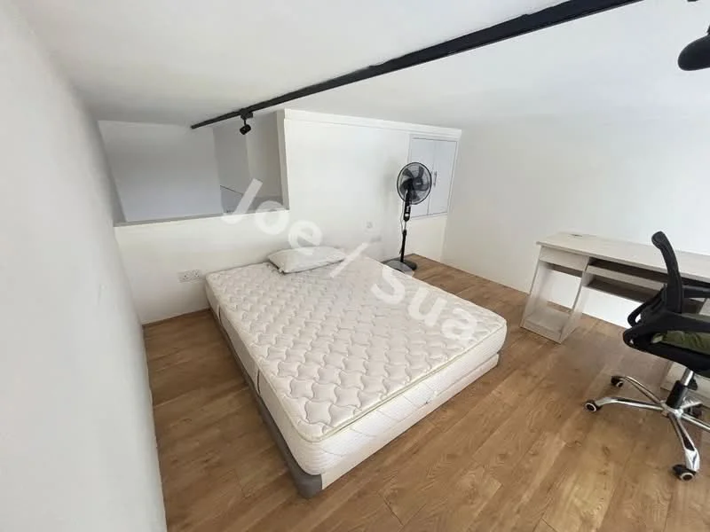 Bedroom features: wooden flooring, white painted walls, single bed mattress, ceiling fan, study desk, office chair, built-in wardrobe, natural light from window.