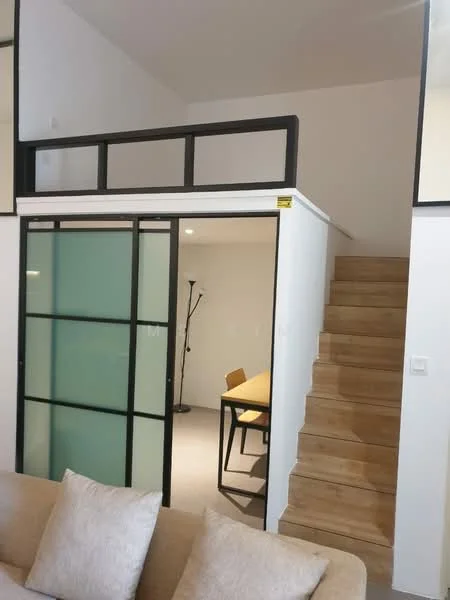 Room features: wooden staircase, glass sliding door with black frame, white painted walls, recessed lighting, laminate flooring, minimalist design, open loft area, dining table with chairs, floor lamp; style: modern.