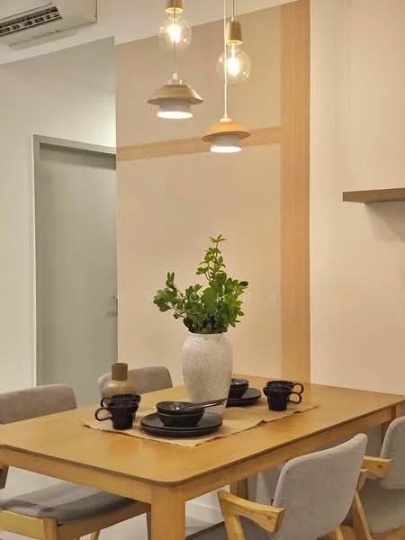 Dining features: wooden dining table, 4 upholstered dining chairs, decorative vase with greenery, black ceramic bowls, black ceramic cups, table runner, pendant lighting with gold accents, light-colored walls with wood accent, wall-mounted shelf; style: modern.