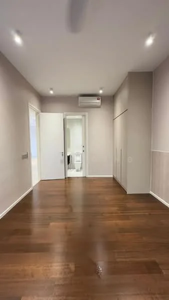Room features: wooden flooring, light grey painted walls, white ceiling with recessed downlights, 1 wall-mounted split AC, double doors, built-in wardrobe, door leading to bathroom, no visible furniture; style: modern.