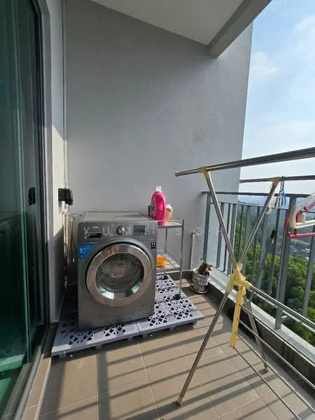 Laundry features: front-load washing machine, metal drying rack, grey tiled flooring, balcony railing, greenery view, plastic laundry basket, detergent bottle, shelf unit; view: garden.