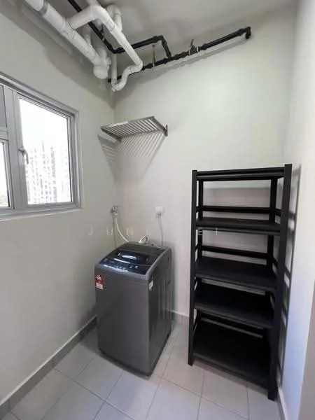 Laundry features: washing machine, black metal shelving unit, white walls, grey tiled flooring, window with view, exposed pipes, wall-mounted drying rack, electrical outlet.