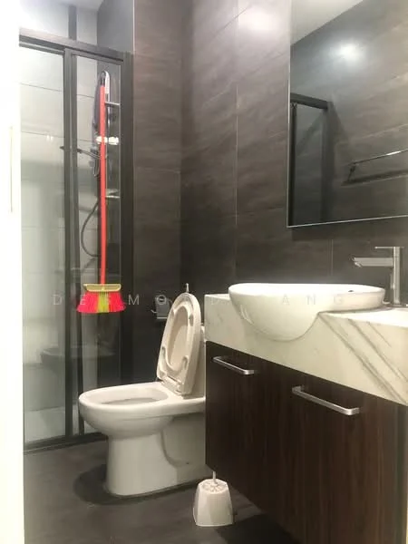 Bathroom features: single-sink vanity with marble top, wood cabinet under sink, chrome basin mixer faucet, framed mirror, one-piece toilet, walk-in shower with glass enclosure, rain shower head, dark ceramic tile flooring, dark wall tiles, shower caddy with cleaning supplies; style: modern.