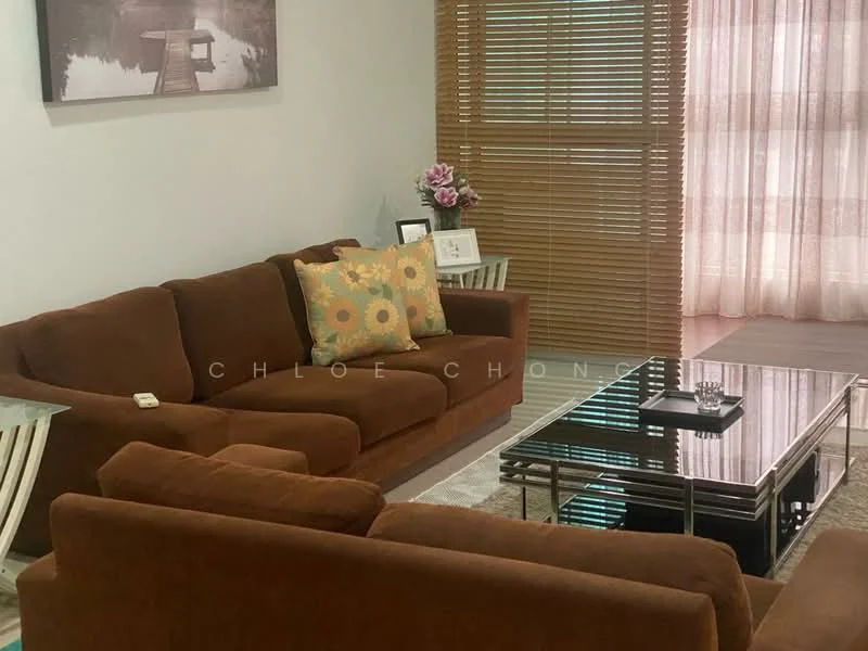 Living features: 3-seater fabric sofa in brown, 2-seater fabric sofa in brown, decorative throw pillow with floral pattern, glass coffee table with metal frame, area rug with neutral tones, wooden side table, framed artwork on wall, window with sheer curtains, wooden blinds, decorative flower arrangement; style: contemporary.