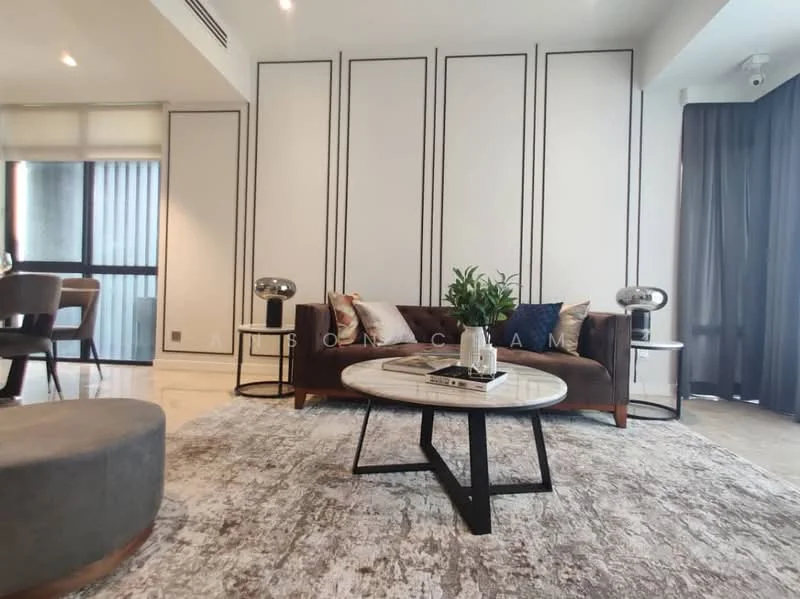 Living features: cream painted walls with black trim, marble flooring, 3-seater brown leather sofa, round coffee table with black base, area rug with abstract pattern, 2 side tables with lamps, floor-to-ceiling windows with sheer curtains, decorative houseplant in ceramic pot; style: modern.