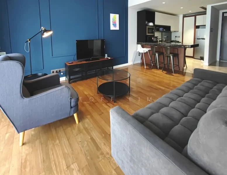 Living features: blue accent wall, light wood flooring, 3-seater grey fabric sofa, 2-seater grey fabric sofa, glass coffee table, floor lamp, wall-mounted TV, open kitchen area visible, bar stools, kitchen island, recessed lighting; style: modern.