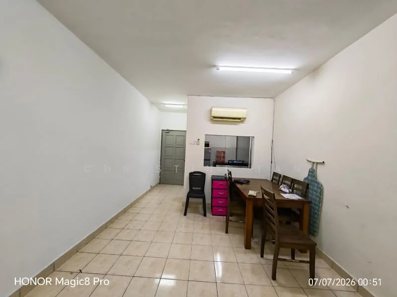 Room features: white painted walls, tile flooring, 1 wall-mounted split AC, 2 wooden chairs, 1 wooden table, pink storage unit, light fixture on ceiling, doorway to another room.