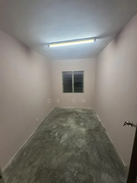Room features: light grey painted walls, concrete flooring, single window with grille, fluorescent ceiling light.
