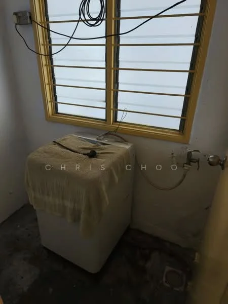 Laundry features: top-load washing machine, yellow framed window, exposed electrical wiring, white walls, concrete flooring, water supply connection, towel draped over washing machine.