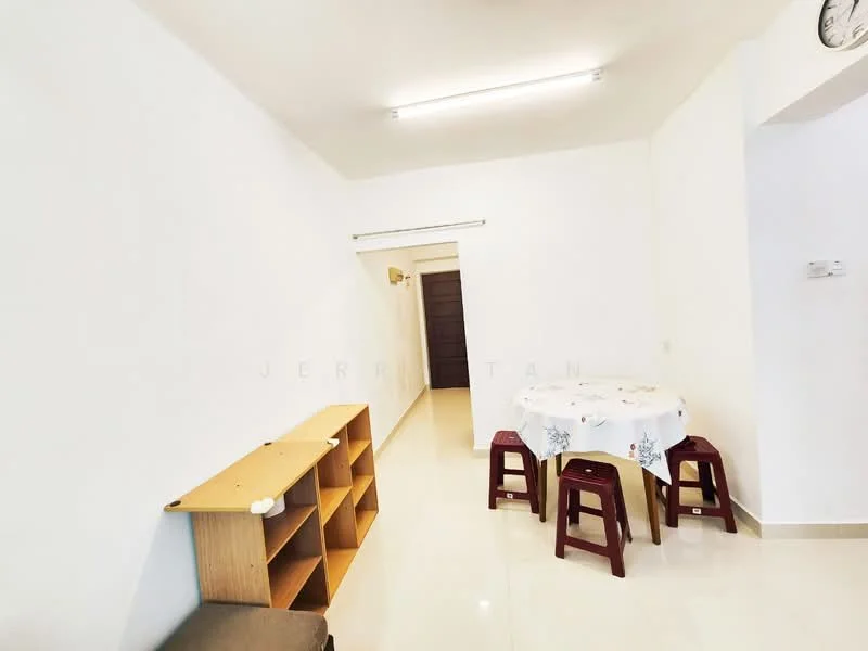 Dining features: white painted walls, glossy tile flooring, round dining table with tablecloth, two red plastic stools, wooden shelving unit, clock on wall, doorway leading to another room, ceiling lights.