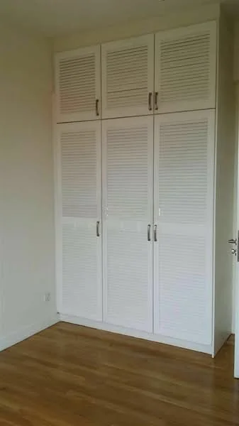 Room features: built-in wardrobe with louvered doors, white cabinetry, wooden flooring, neutral wall color, door frame, light switch; style: modern.