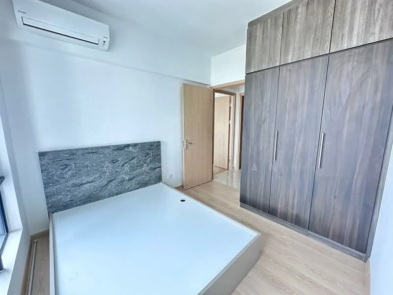 Bedroom features: wooden flooring, white painted walls, built-in wardrobe with wood finish, air conditioning unit, large window with natural light, minimalist design, empty bed frame, neutral color palette; style: modern.