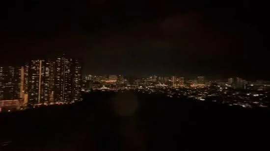 Exterior type: high-rise condominium; features: city skyline view, illuminated buildings, nighttime lighting, surrounding urban landscape; style: modern.