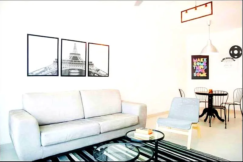 Living features: light grey fabric sofa, black and white framed artwork, area rug with geometric pattern, coffee table, pendant light, white walls, recessed ceiling lights, floor-to-ceiling windows, decorative wall art, black dining chairs, round dining table; style: modern.