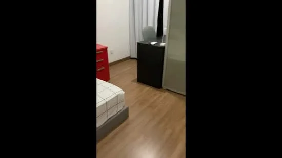 Bedroom features: wooden flooring, white painted walls, single bed with checkered bedding, red bedside table, black study desk, chair, sliding wardrobe, curtains, lamp on desk; style: modern.