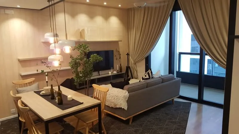 Living features: grey fabric sofa, wooden coffee table, area rug with geometric pattern, wall-mounted TV, shelf unit, pendant lighting with multiple bulbs, floor-to-ceiling windows, curtains, decorative plants, wooden dining table, wooden dining chairs; style: modern; view: city.