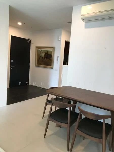 Dining features: wooden dining table, 4 wooden dining chairs with black cushions, white painted walls, light-colored flooring, wall-mounted air conditioning unit, framed artwork on wall, black door, dark flooring near entrance; style: modern.