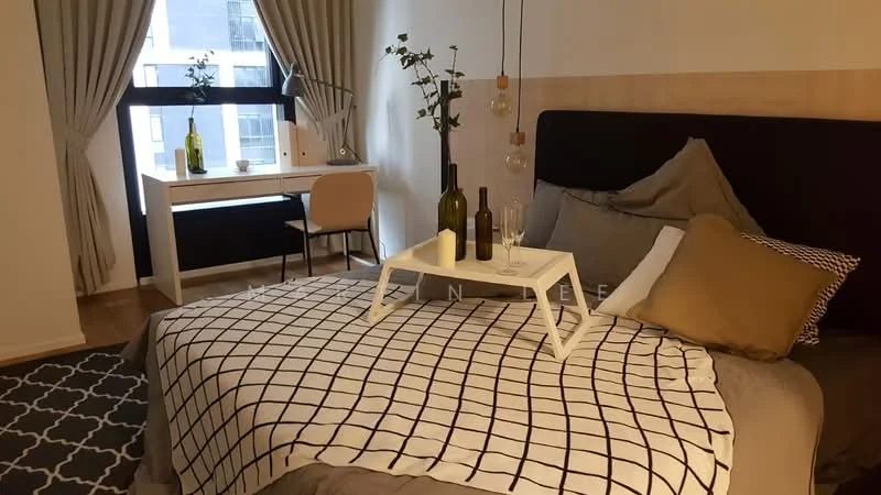 Bedroom features: king-size bed with grey bedding, upholstered headboard, decorative throw pillows, white and black patterned throw blanket, wooden bedside table, two green glass bottles, two wine glasses, desk with white surface, pink chair, floor-to-ceiling window with sheer curtains, wooden flooring, area rug with geometric pattern, wall-mounted decorative plants; style: modern; view: city.