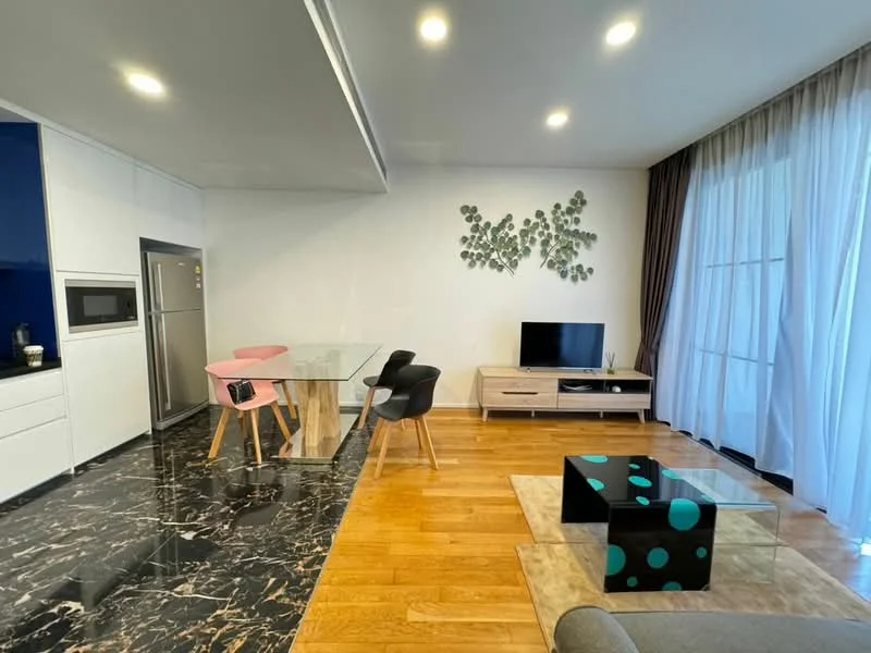 Living features: black marble flooring, wood flooring, floor-to-ceiling windows, white painted walls, recessed downlights, wall-mounted TV, TV console, coffee table with geometric pattern, sofa in grey fabric, dining table with glass top, 4 dining chairs in pink and black, decorative wall art with green leaves; style: modern.