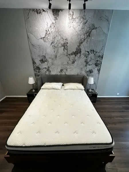 Bedroom features: king-size bed, upholstered headboard, two bedside lamps, dark wood nightstands, marble accent wall, wooden flooring, track lighting, neutral wall color; style: modern.