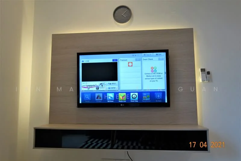 Living features: wall-mounted TV, wooden TV console, decorative wall panel, clock on wall, LED strip lighting, black open shelving, neutral wall color, flooring not visible; style: modern.