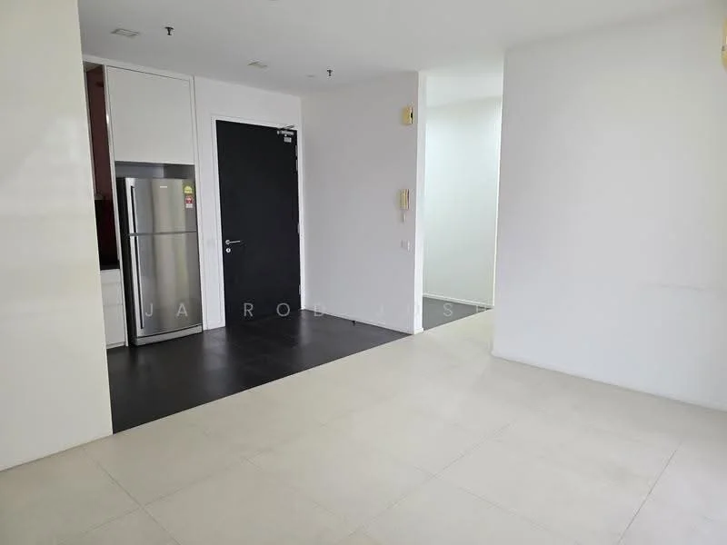 Room features: white painted walls, light-colored tile flooring, black tile flooring, stainless-steel fridge, black door, open layout, recessed lighting, kitchen cabinetry; style: modern.