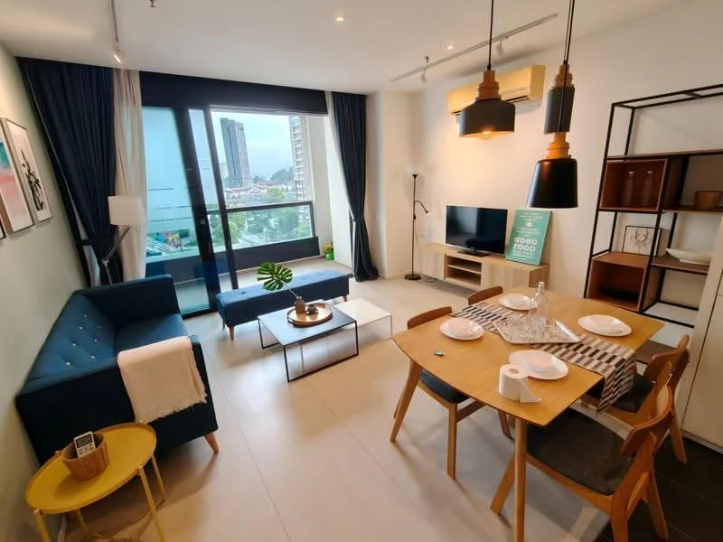 Living features: blue fabric sofa, glass coffee table, wooden dining table, four wooden dining chairs, TV console, wall-mounted TV, floor lamp, decorative plant on table, white walls, large sliding glass door, curtains, air conditioning unit, area rug; style: modern; view: city.