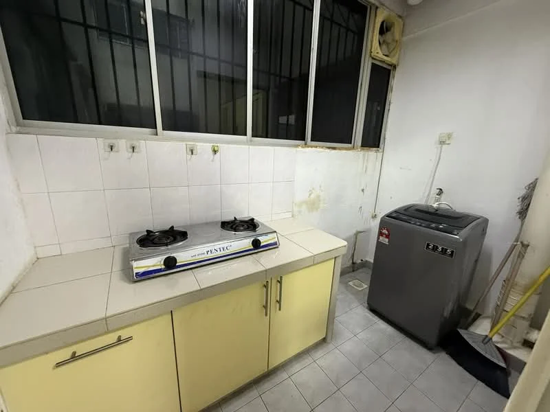 Kitchen features: two-burner gas hob, stainless-steel sink, yellow cabinetry, white tiled backsplash, grey tiled flooring, window with metal grilles, washing machine, countertop with space for appliances, wall-mounted faucet, exposed plumbing, light fixture, cleaning supplies.