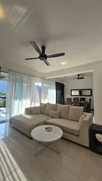 Living features: L-shape sectional sofa in cream, round coffee table with glass top, 5-blade ceiling fan with light, recessed downlights, floor-to-ceiling windows with sheer curtains, sliding glass door leading to outdoor space, tile flooring, decorative wall art, black accent chair; style: modern; view: garden.